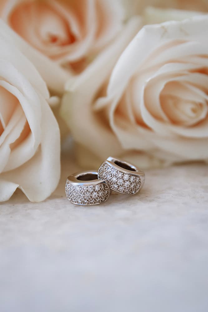 Anillos de boda entre rosas blancas